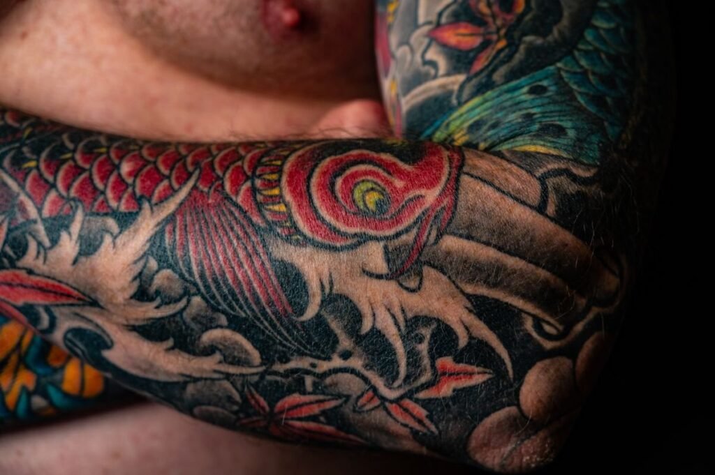 Manche de tatouage japonaise en couleur avec une carpe koi sur tout le bras
